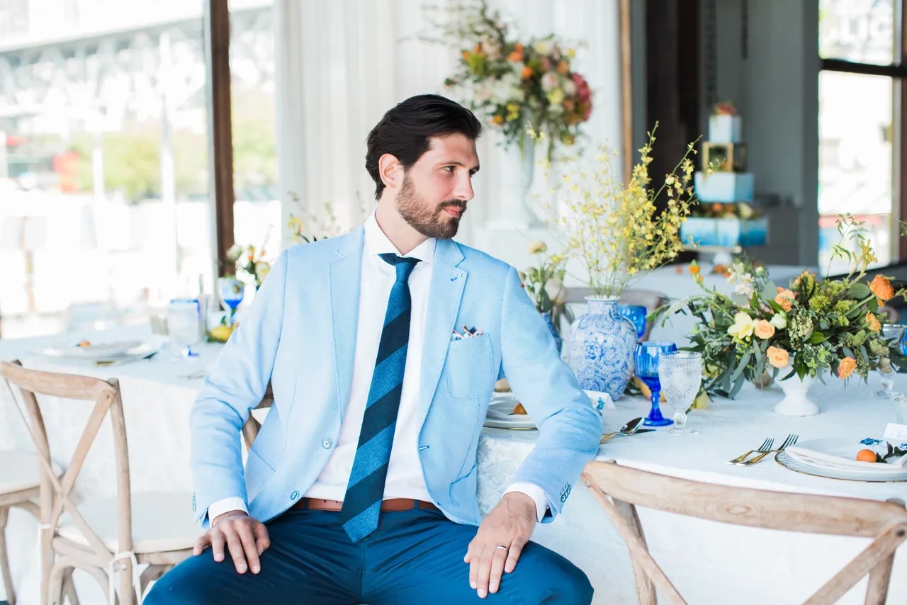 The groom at the table, styled in cobalt blue.